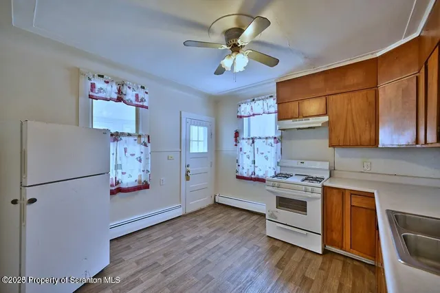 a kitchen with stainless steel appliances granite countertop a refrigerator a stove top oven a sink and dishwasher