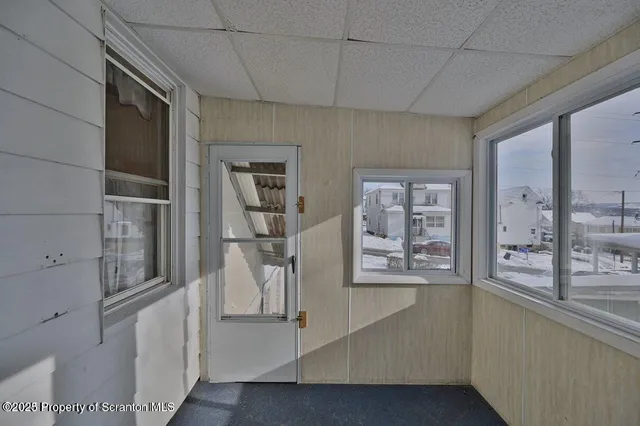 a view of a hallway with a large window and cabinet