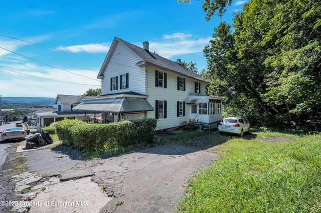 a view of a house with a yard and sitting area