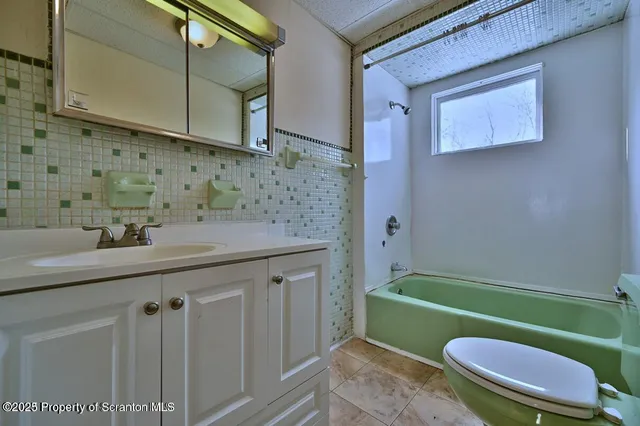 a bathroom with a sink a toilet a mirror and bathtub