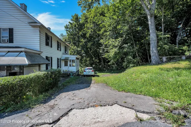 a front view of a house with a yard and trees
