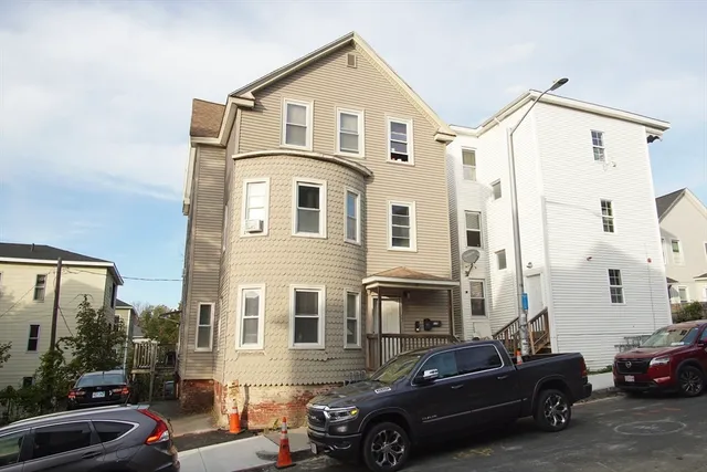 a front view of a house with cars parked