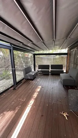 a view of a room with wooden floor and windows