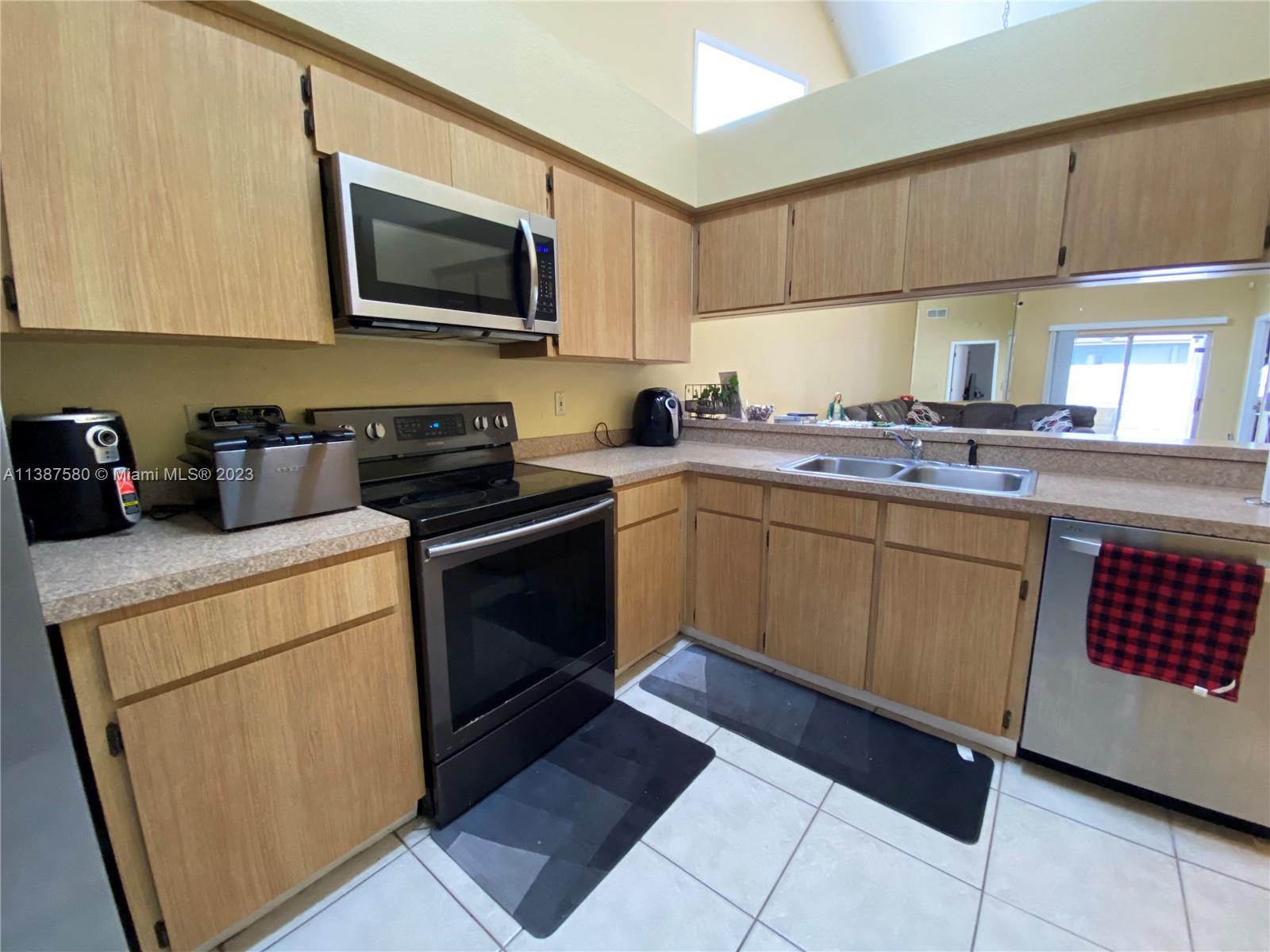 11652 Sunshine Pond Road Tampa, FL 33635 - Photo 11 of 39 a kitchen with a sink stove and microwave