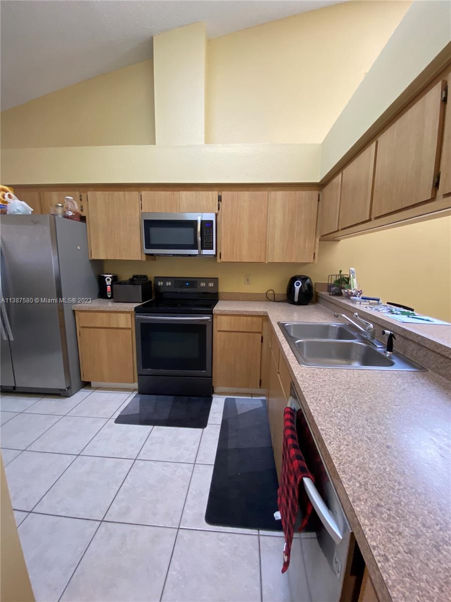 11652 Sunshine Pond Road Tampa, FL 33635 - Photo 12 of 39 a kitchen with stainless steel appliances a sink a stove top oven a counter space and cabinets