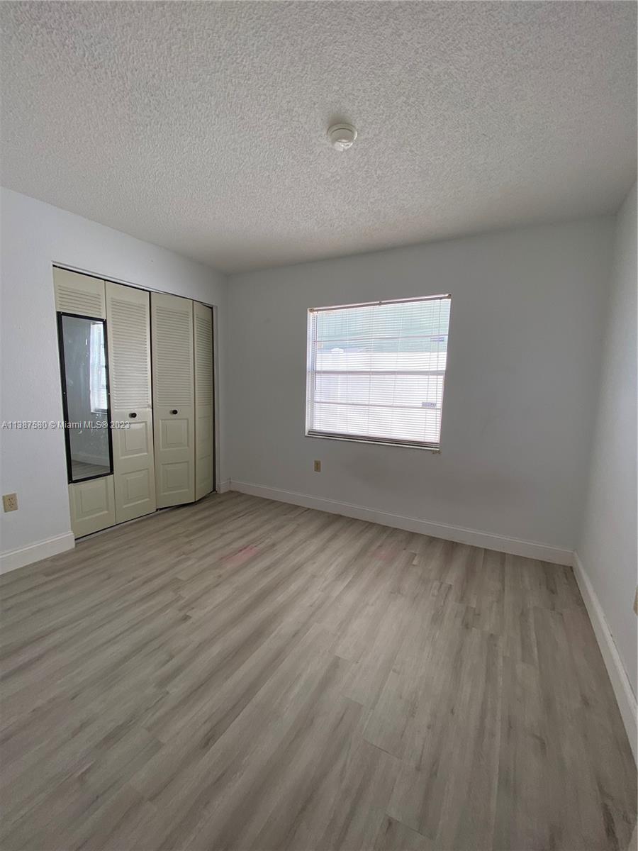 11652 Sunshine Pond Road Tampa, FL 33635 - Photo 17 of 39 an empty room with wooden floor and windows