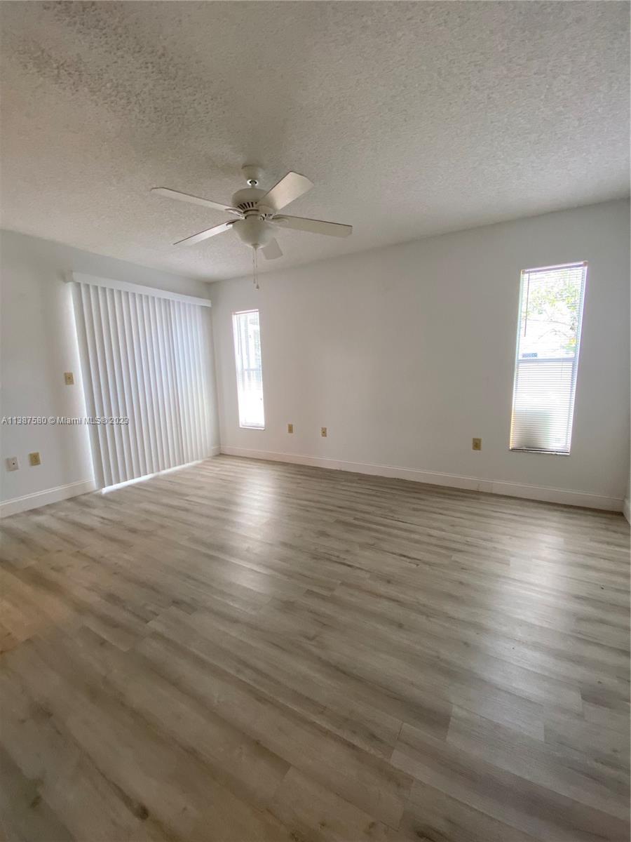 11652 Sunshine Pond Road Tampa, FL 33635 - Photo 19 of 39 an empty room with wooden floor and windows