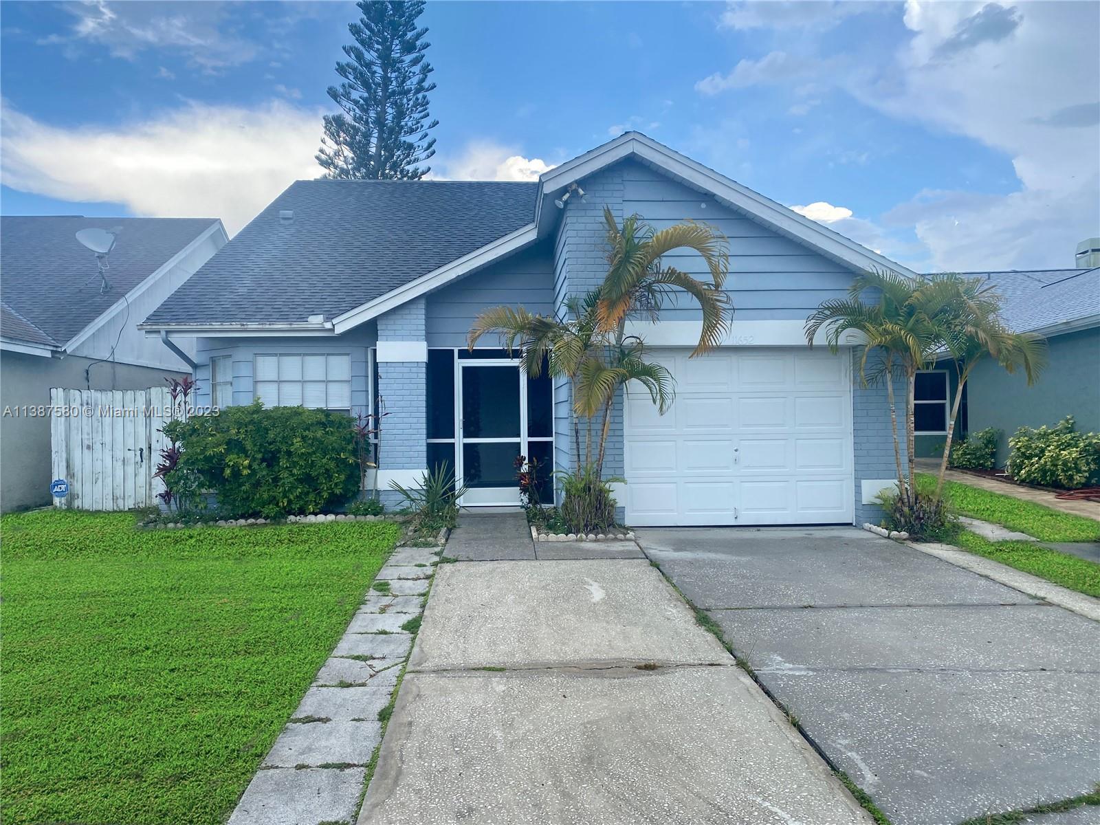 11652 Sunshine Pond Road Tampa, FL 33635 - Photo 2 of 39 a front view of a house with a yard and garage