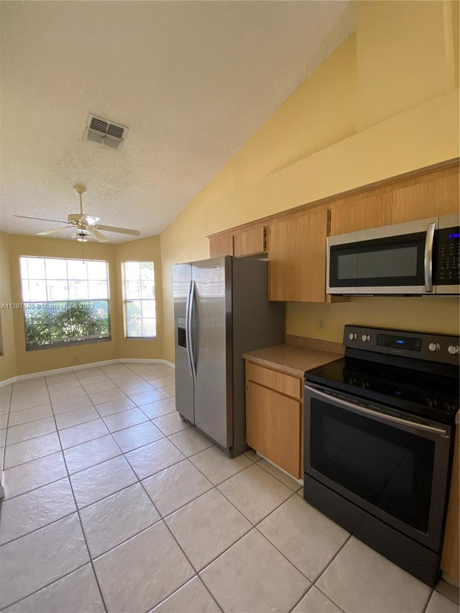 11652 Sunshine Pond Road Tampa, FL 33635 - Photo 9 of 39 a kitchen with stainless steel appliances a refrigerator and a stove top oven
