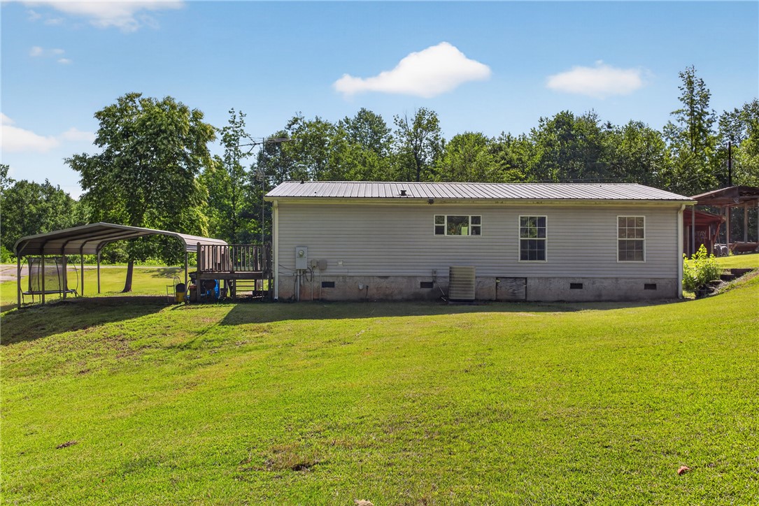 418 Chauga Road Westminster, SC 29693 - Photo 27 of 38 A verdant backyard with ample space, offering both a covered patio and a separate carport.