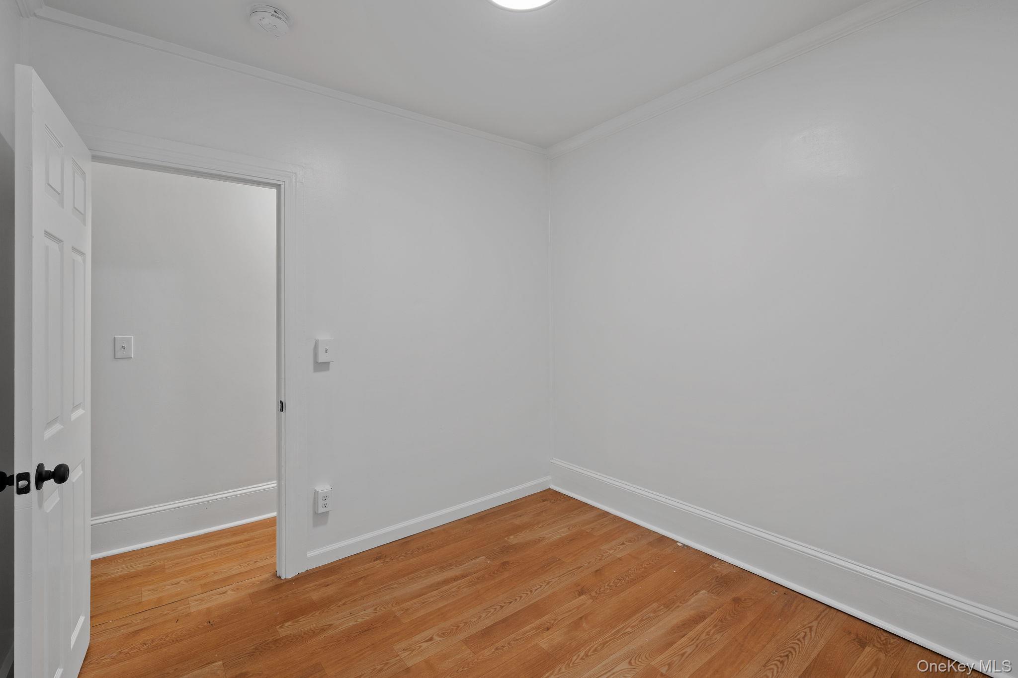 93 Delafield Street Poughkeepsie, NY 12601 - Photo 16 of 27 Unfurnished room with wood finished floors and crown molding