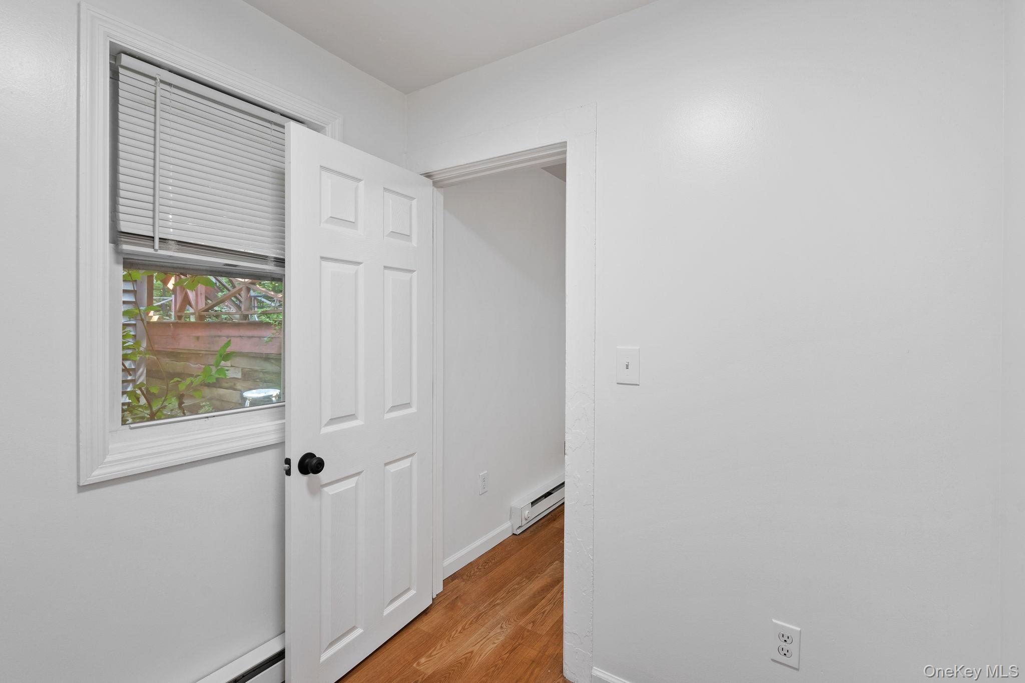 93 Delafield Street Poughkeepsie, NY 12601 - Photo 17 of 27 Corridor featuring light wood finished floors, baseboard heating, and a baseboard heating unit
