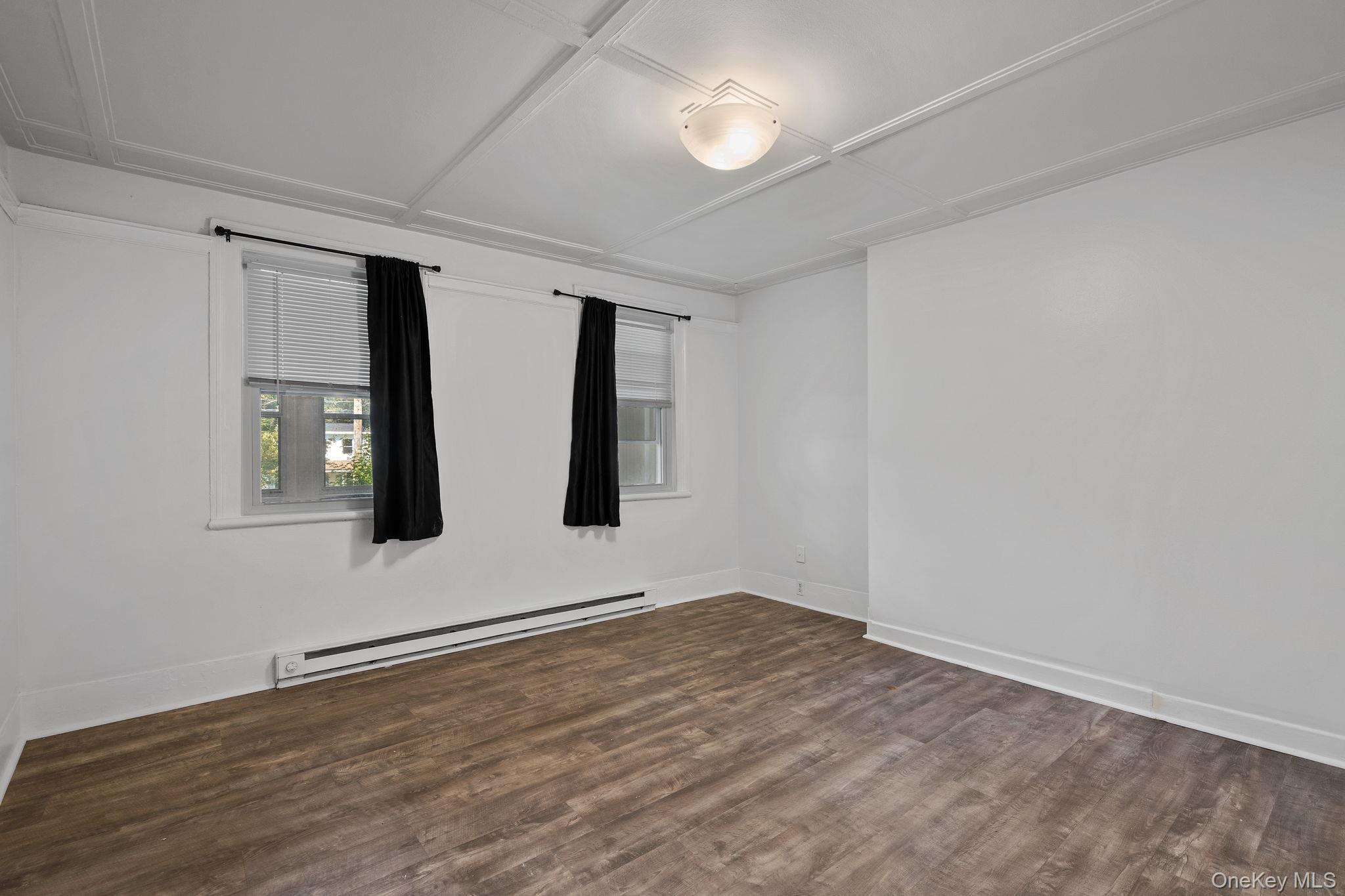 93 Delafield Street Poughkeepsie, NY 12601 - Photo 7 of 27 Spare room with a baseboard radiator and dark wood-type flooring