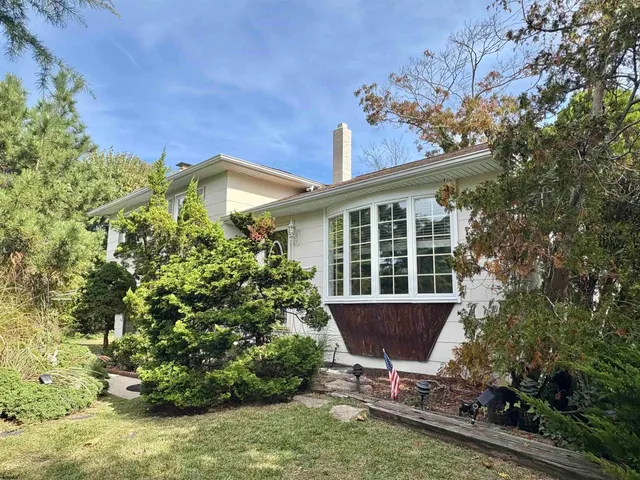a view of a house with a yard and sitting area