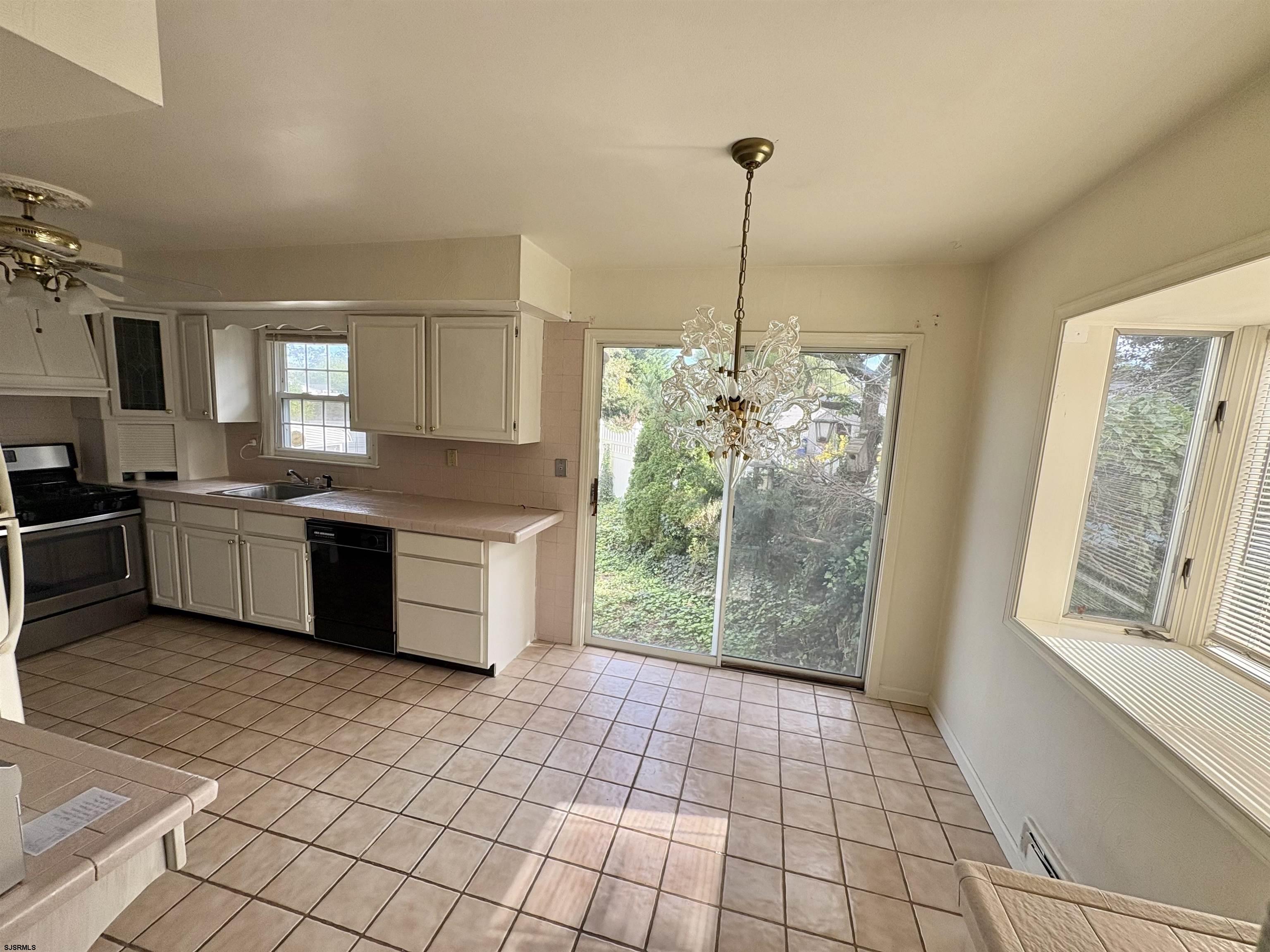 101 Haddon Road Somers Point, NJ 08244 - Photo 9 of 18 a kitchen with stainless steel appliances granite countertop a stove a sink a window and cabinetry