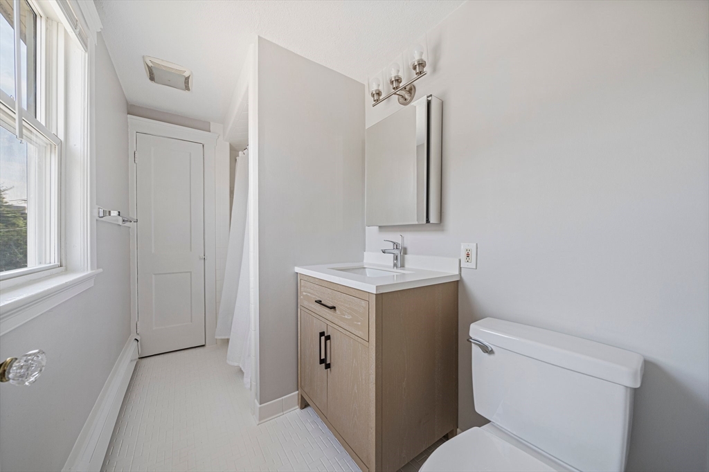 14 Hartwell Street, Unit B Waltham, MA 02453 - Photo 12 of 24 a bathroom with a toilet sink and mirror