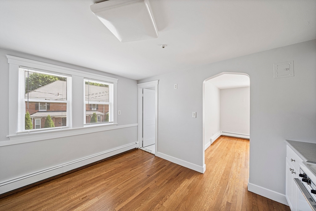 14 Hartwell Street, Unit B Waltham, MA 02453 - Photo 4 of 24 an empty room with wooden floor and windows