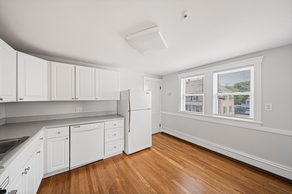 14 Hartwell Street, Unit B Waltham, MA 02453 - Photo 5 of 24 a kitchen with granite countertop white cabinets and sink