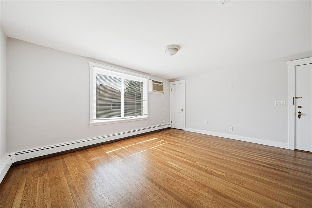 14 Hartwell Street, Unit B Waltham, MA 02453 - Photo 6 of 24 a view of an empty room with wooden floor and a window