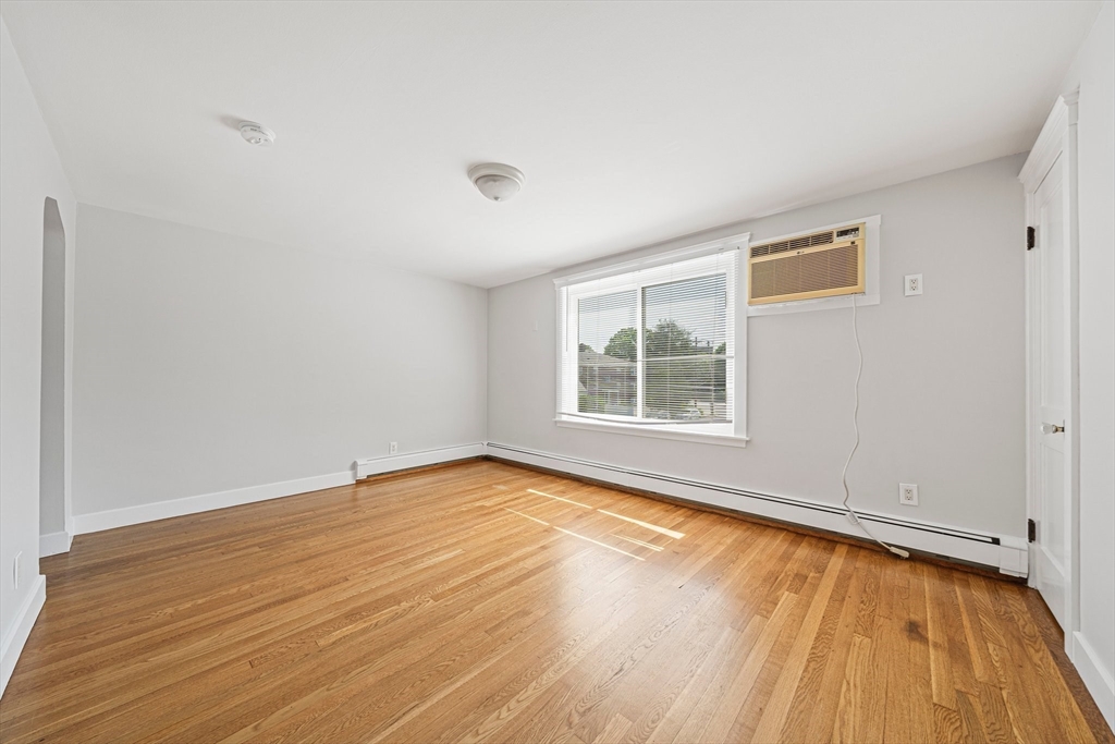14 Hartwell Street, Unit B Waltham, MA 02453 - Photo 9 of 24 a view of an empty room with wooden floor and a window