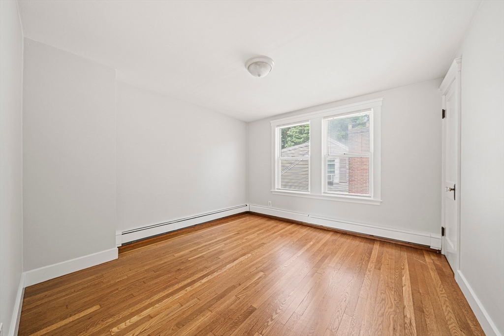 14 Hartwell Street, Unit B Waltham, MA 02453 - Photo 10 of 24 an empty room with wooden floor and windows