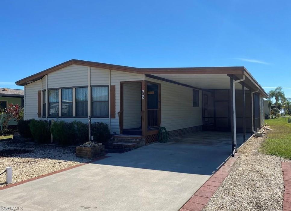 76 Atlantic Way, Unit 76 Naples, FL 34104 - Photo 1 of 18 Manufactured / mobile home with concrete driveway, a sunroom, and a carport