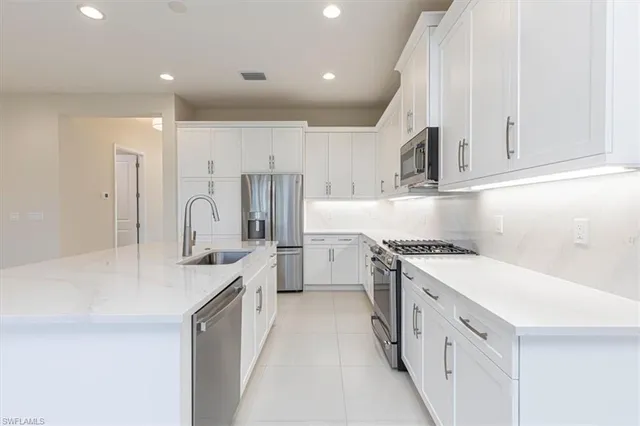 a kitchen with kitchen island a counter top space stainless steel appliances and cabinets