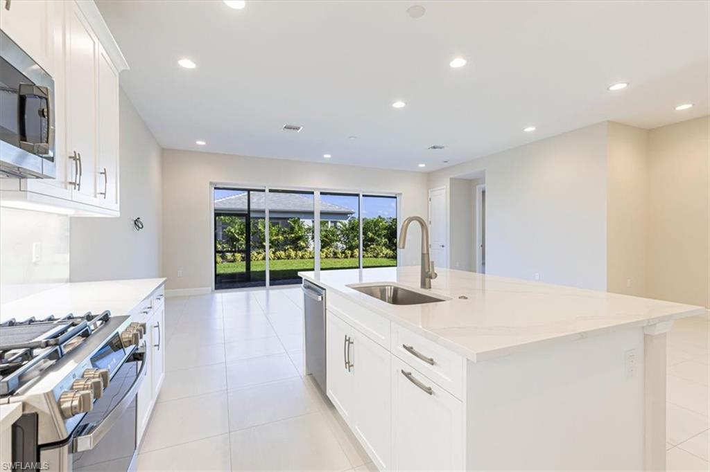 2749 Durham Circle Naples, FL 34112 - Photo 8 of 30 a kitchen with a sink stove and cabinets