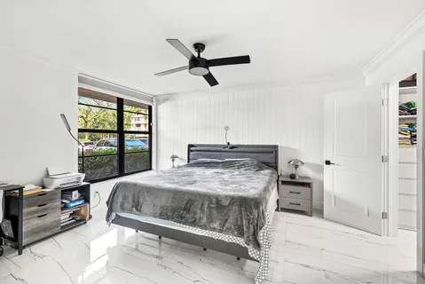 a bedroom with a bed a table and a large window