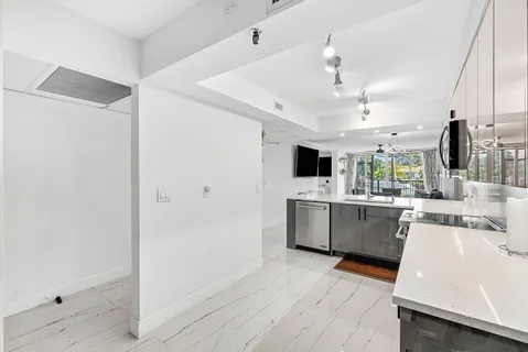 a kitchen with white cabinets and sink