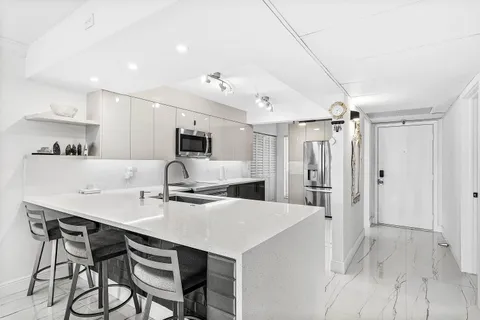 a kitchen with kitchen island a stove a table and chairs in it