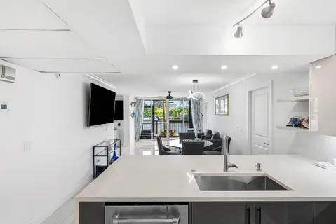 a view of kitchen with kitchen island a sink and a refrigerator