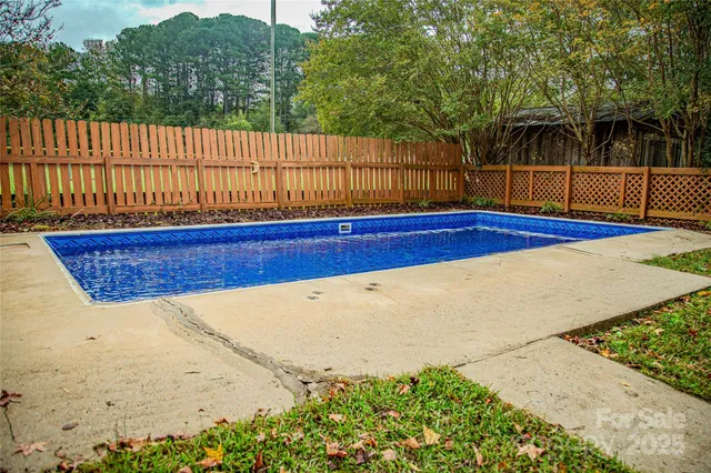 a view of a backyard with fence and trees