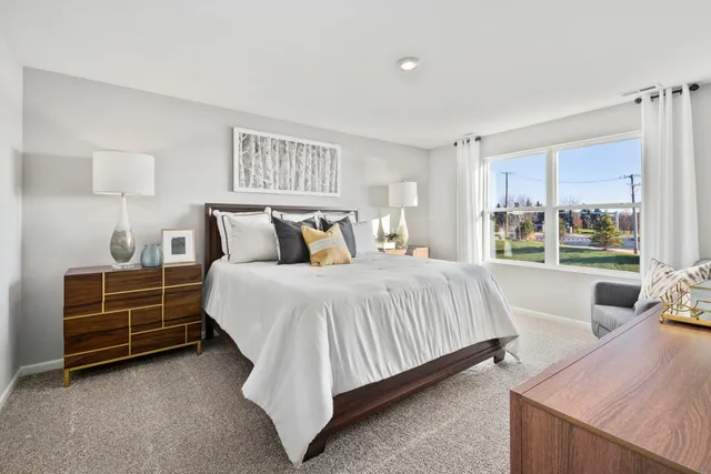 a bedroom with a bed and a large window