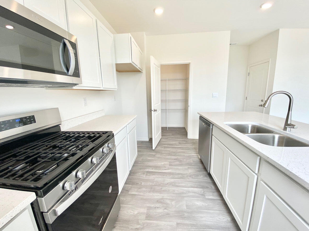585 Marcella Street Hebron, IN 46341 - Photo 7 of 21 a kitchen with stainless steel appliances granite countertop a stove and a sink