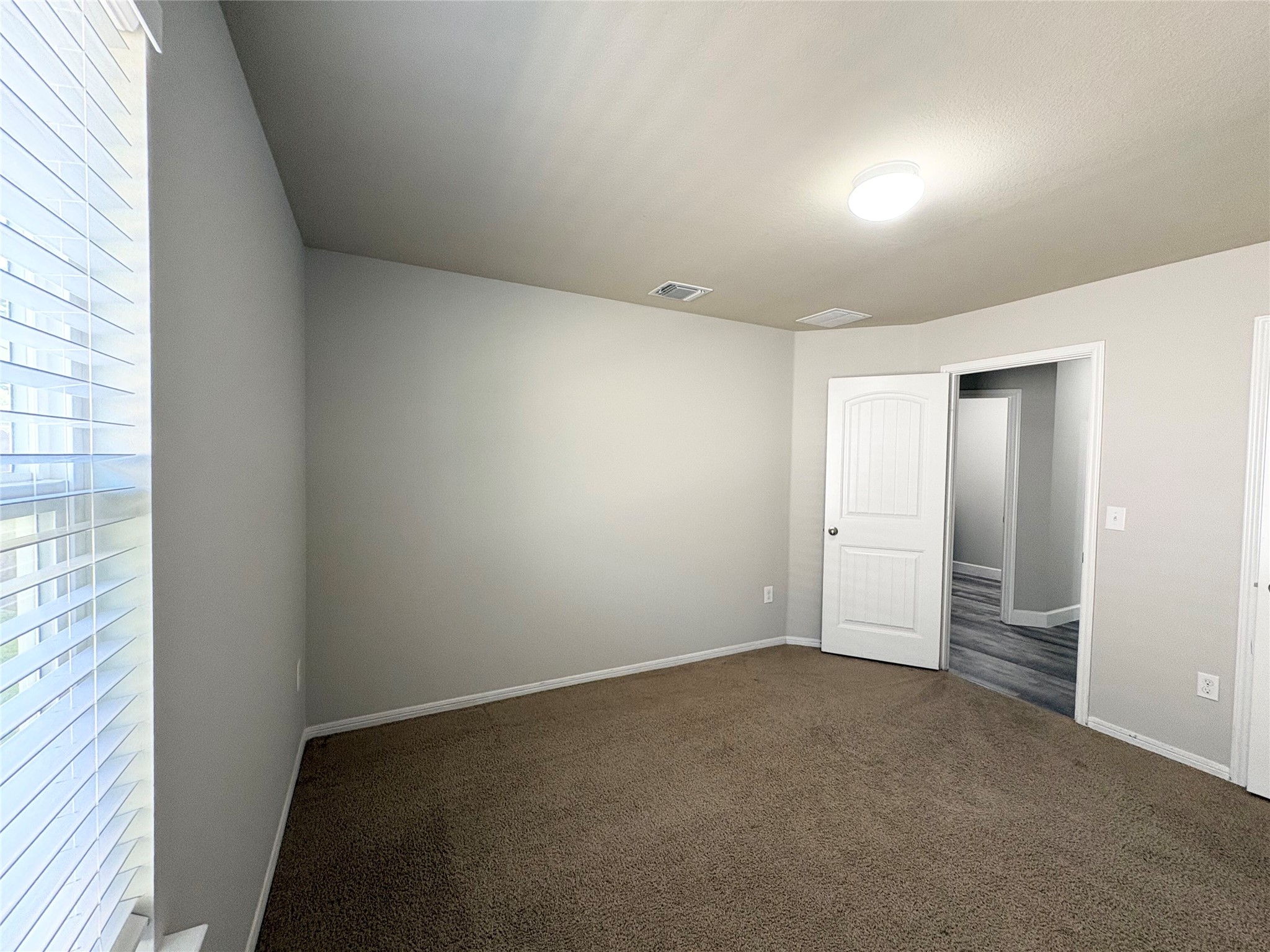 11708 Cambrian Road Manor, TX 78653 - Photo 20 of 31 A spacious room offers ample natural light and plush carpeting, perfect for restful nights.