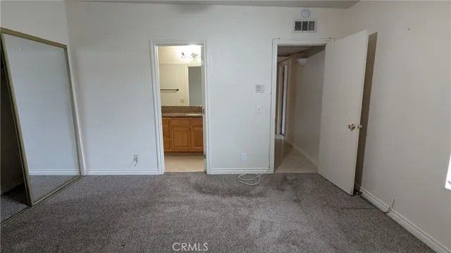 an empty room with closet and mirror