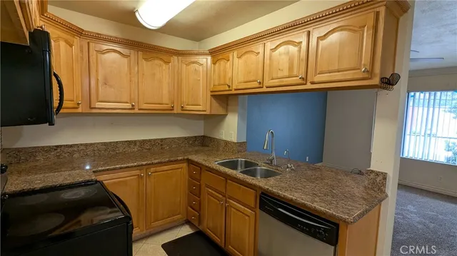 a kitchen with granite countertop a sink stove and cabinets