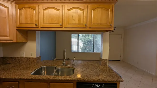 a kitchen with granite countertop a sink and cabinets