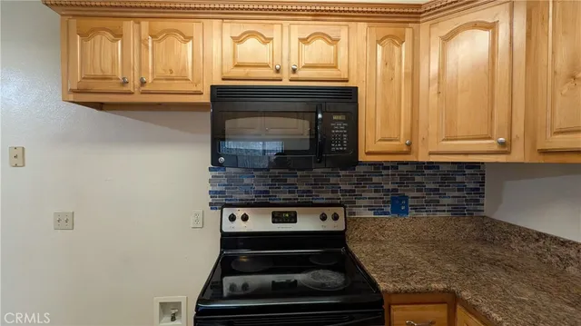 a kitchen with granite countertop a stove and a cabinet