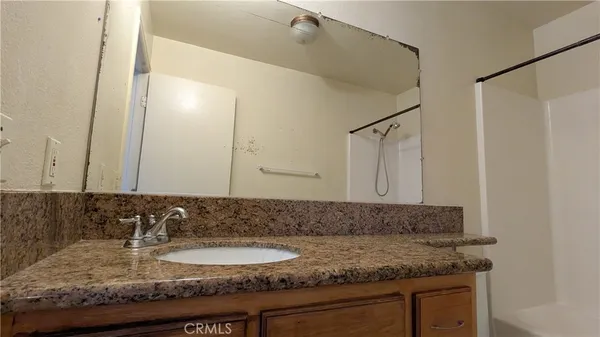 a bathroom with a granite countertop sink and a mirror