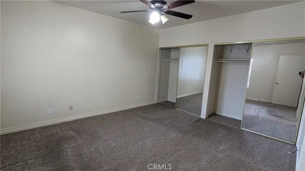 a view of an empty room with a ceiling fan