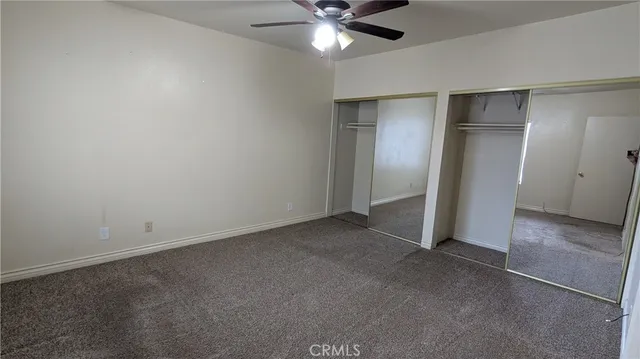 a view of an empty room with a ceiling fan