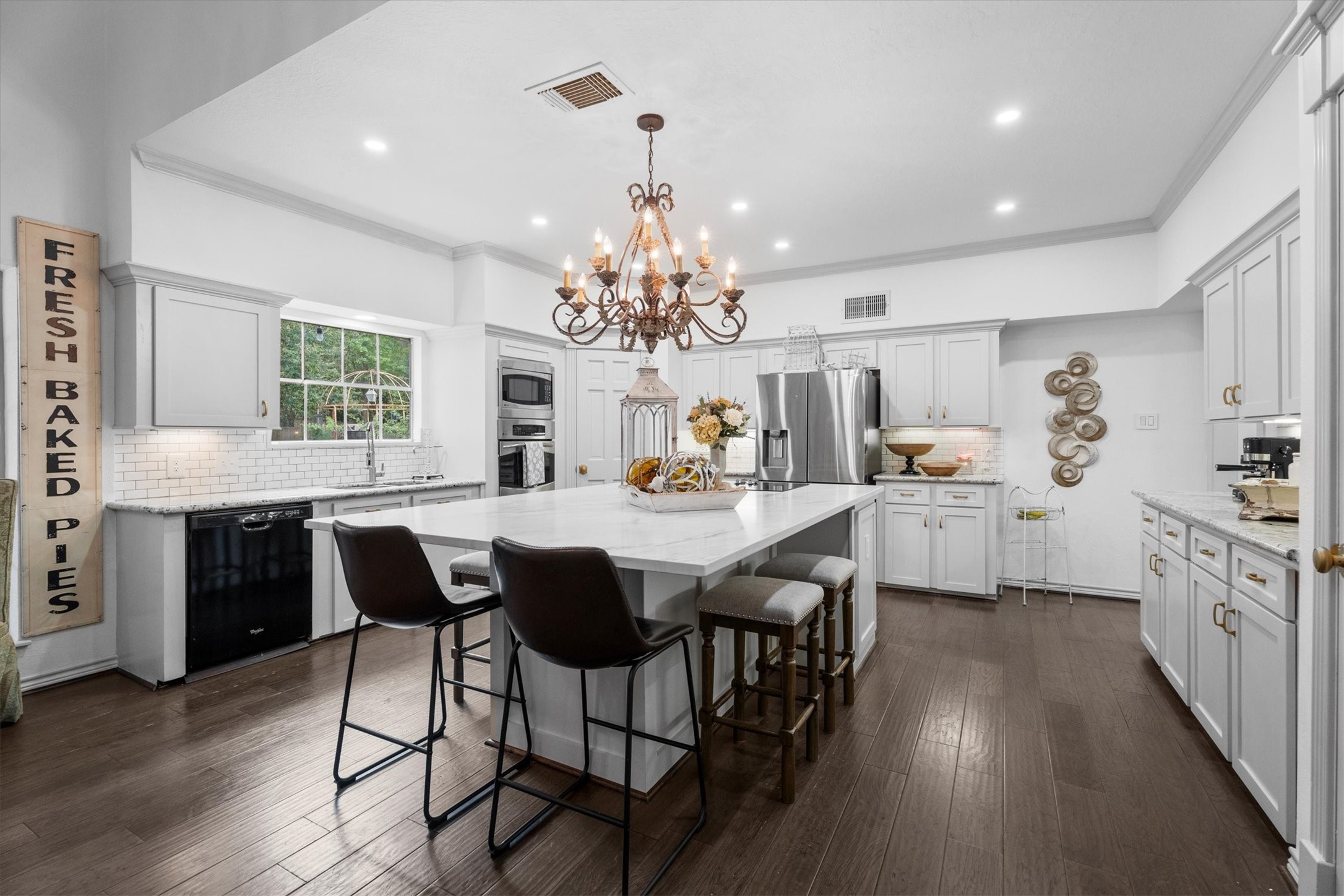 15902 Guinstead Drive Spring, TX 77379 - Photo 2 of 42 Spacious, modern kitchen featuring a large island with seating, stainless steel appliances, and ample white cabinetry.