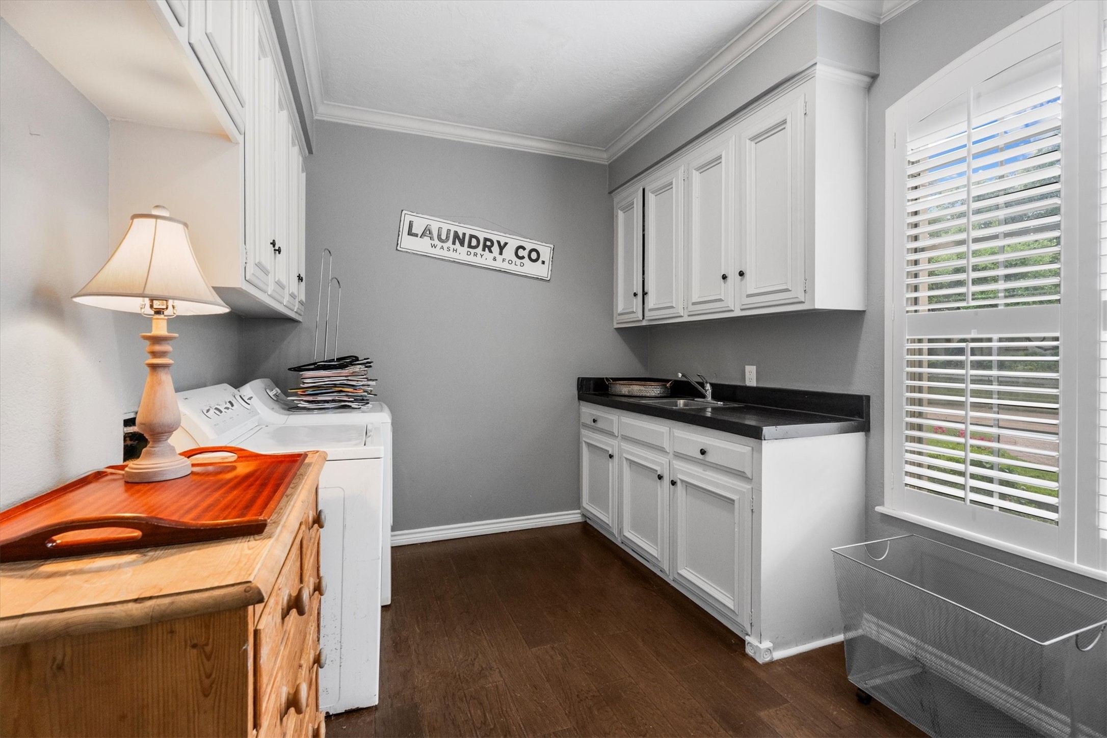 15902 Guinstead Drive Spring, TX 77379 - Photo 24 of 42 Laundry room with ample natural light, showcasing white cabinetry and dark countertops.