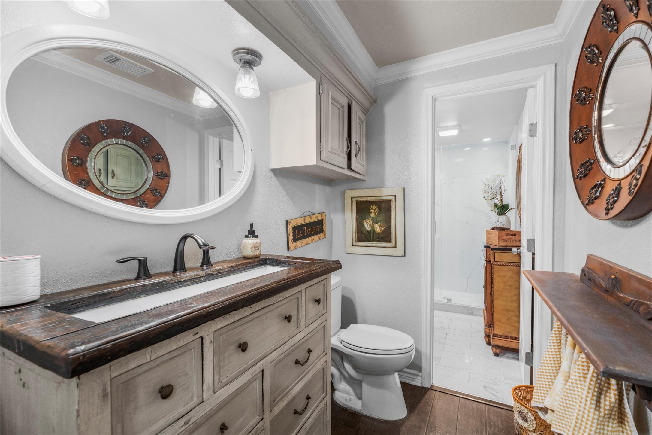 15902 Guinstead Drive Spring, TX 77379 - Photo 25 of 42 Bathroom featuring a rustic vanity with a dark wood countertop and an oval mirror.