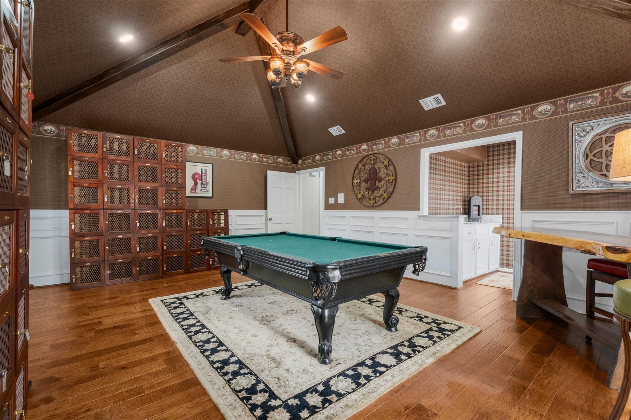 15902 Guinstead Drive Spring, TX 77379 - Photo 27 of 42 Stylish game room with elegant wood flooring, and built-in lockers. The vaulted ceiling with exposed beams adds character, while the warm lighting create a cozy, inviting atmosphere.