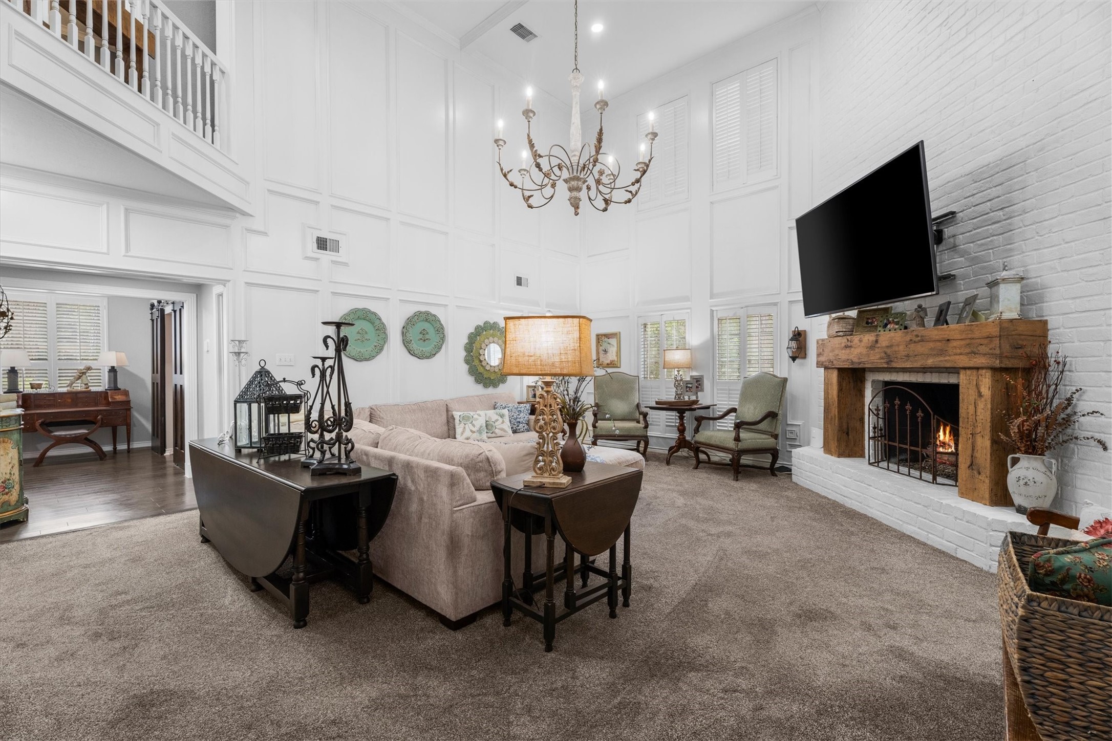 15902 Guinstead Drive Spring, TX 77379 - Photo 4 of 42 Spacious living room features high ceilings, a cozy fireplace with a rustic wooden mantel, and an elegant chandelier.