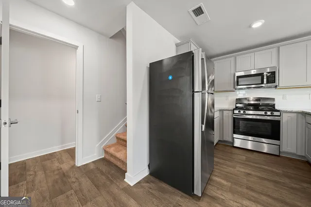 a kitchen with stainless steel appliances a refrigerator and a stove top oven
