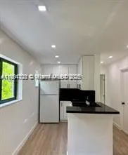 a view of a kitchen with cabinets and wooden floor